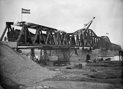 222811 Gezicht op de van oorlogsschade herstelde spoorbrug over de Maas bij Hedel, met enkele Duitse stoomlocomotieven ...